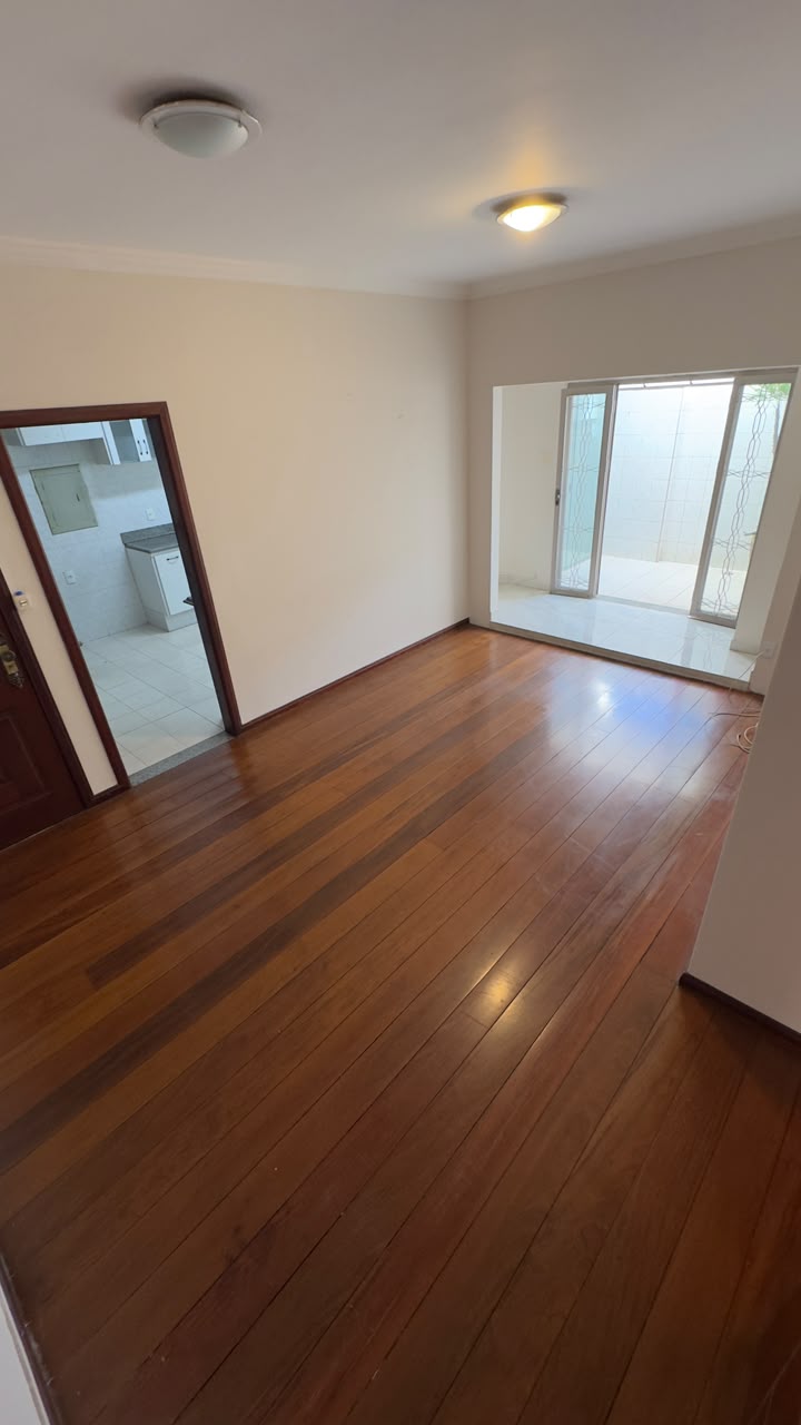Sala ampla com piso de madeira do apartamento à venda no Centro de Pouso Alegre