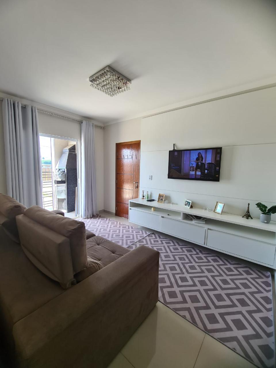 Sala com painel planejado e saída para a varanda