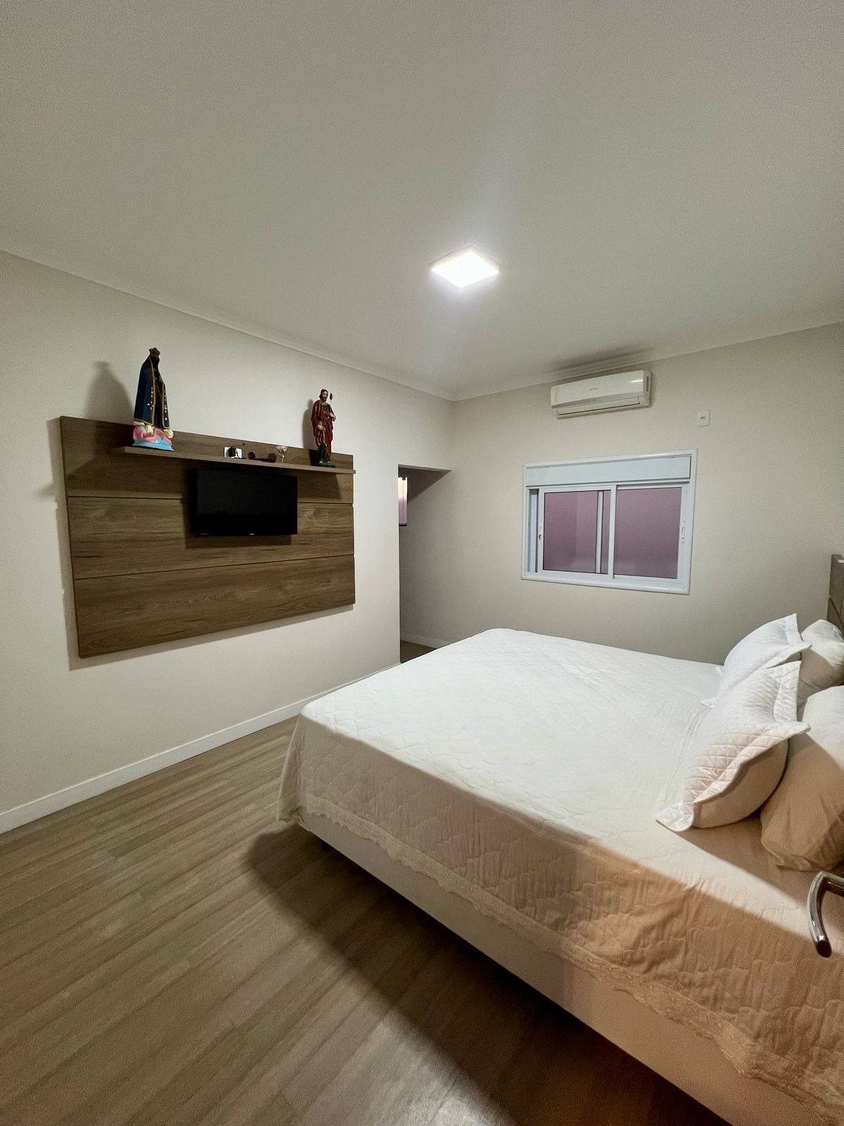 Suíte com ar-condicionado e piso laminado