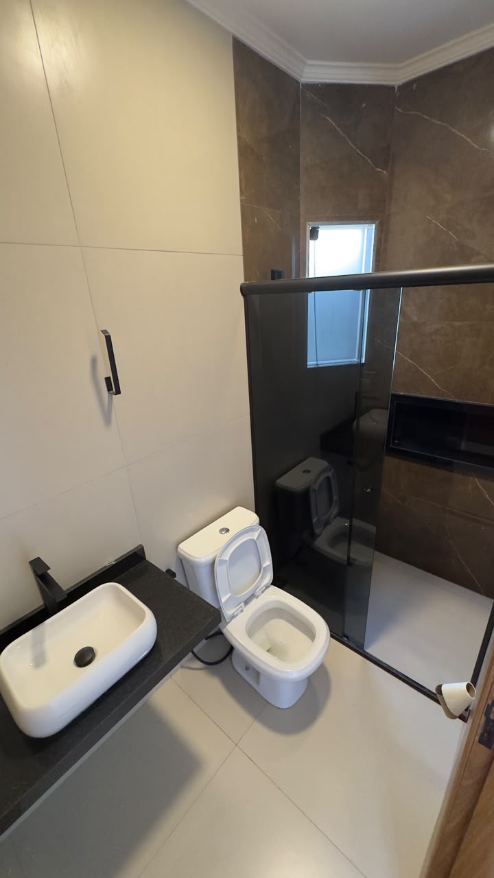 Banheiro da suíte com box de vidro fumê
