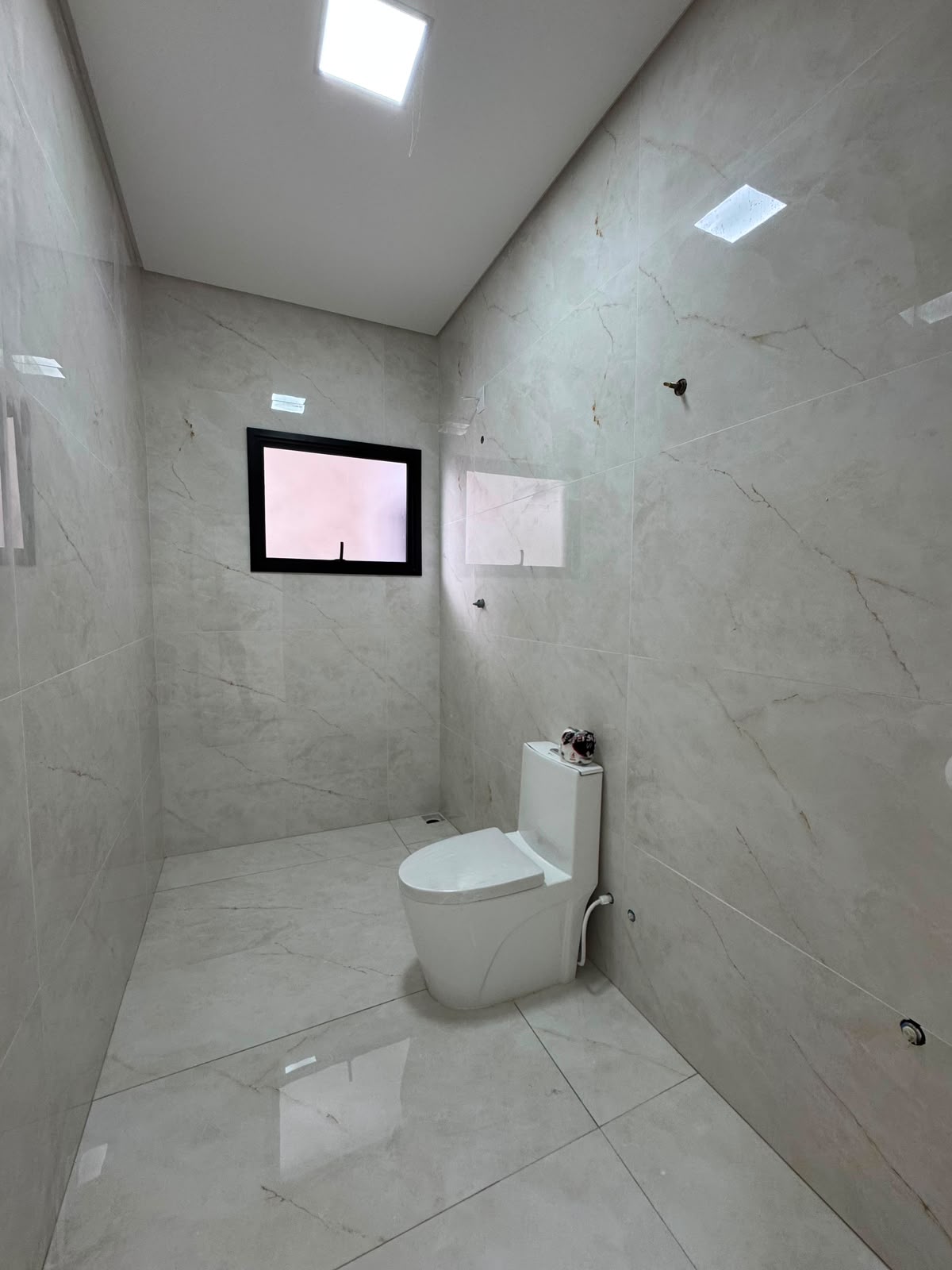 Banheiro da suíte em porcelanato marmorizado