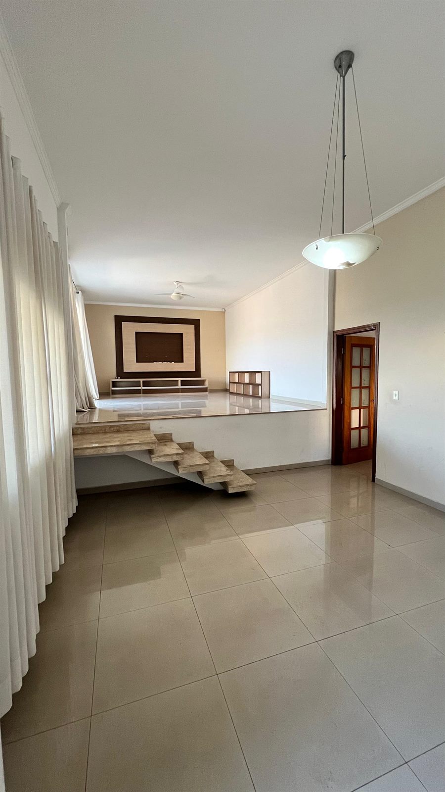 Sala ampla em dois níveis com escada de mármore