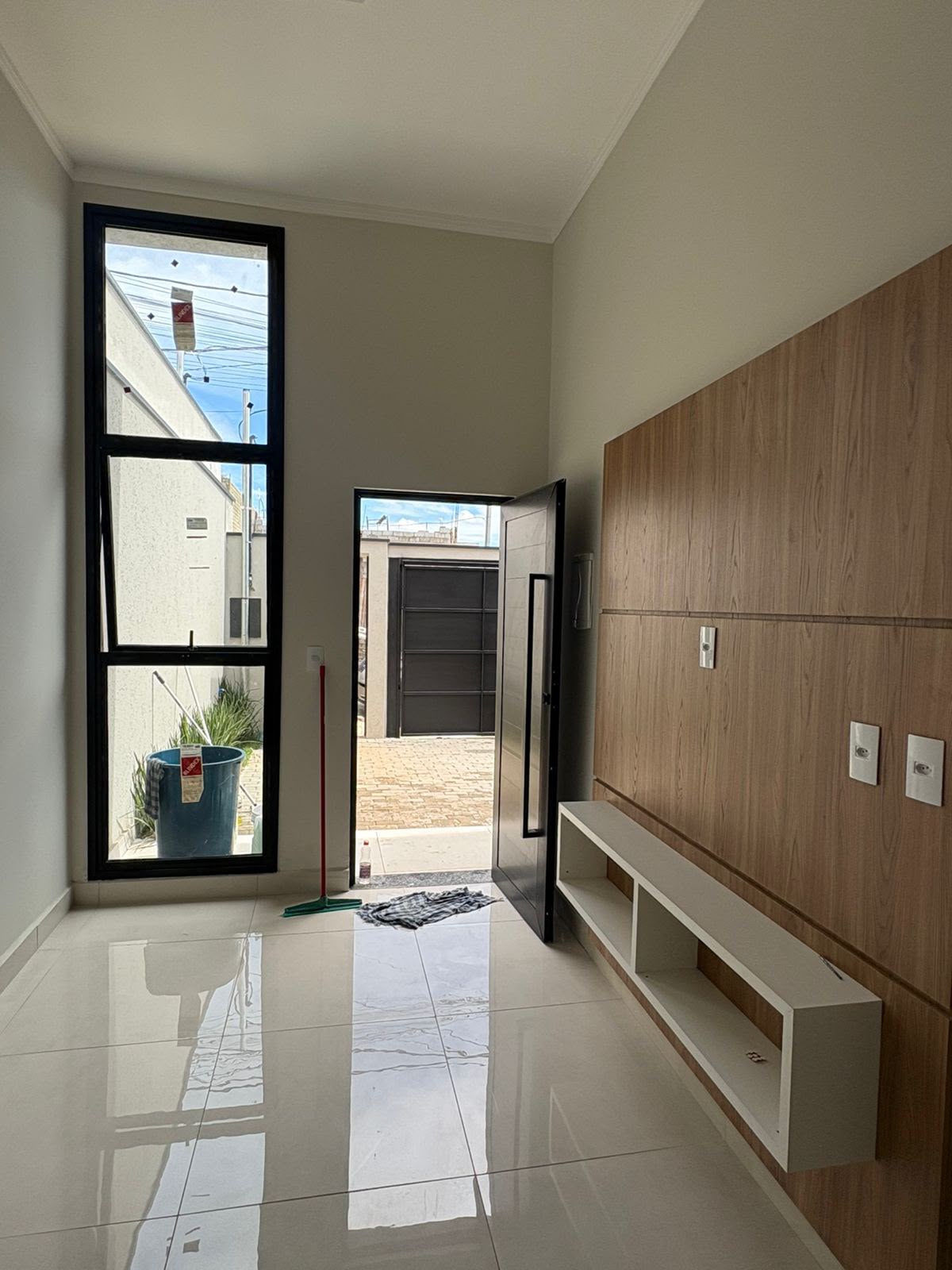 Sala com pé-direito alto e porta pivotante