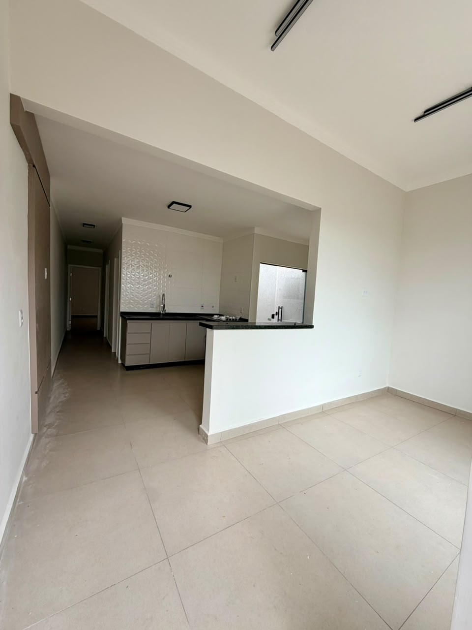 Sala, outro ângulo, com corredor dos quartos e cozinha ao fundo