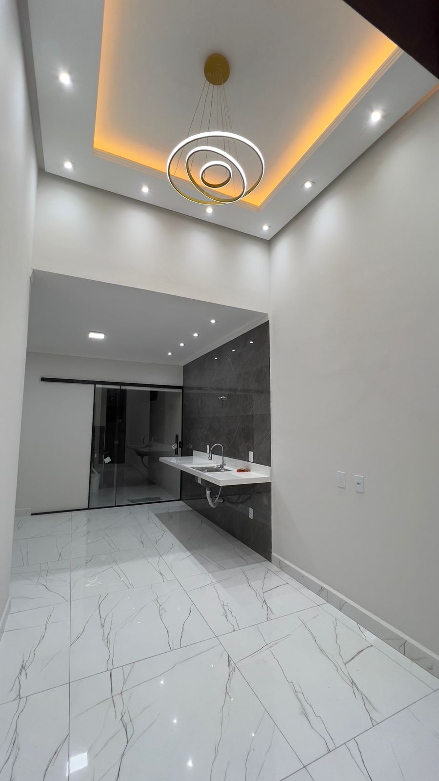 Sala com pé-direito alto e sanca iluminada
