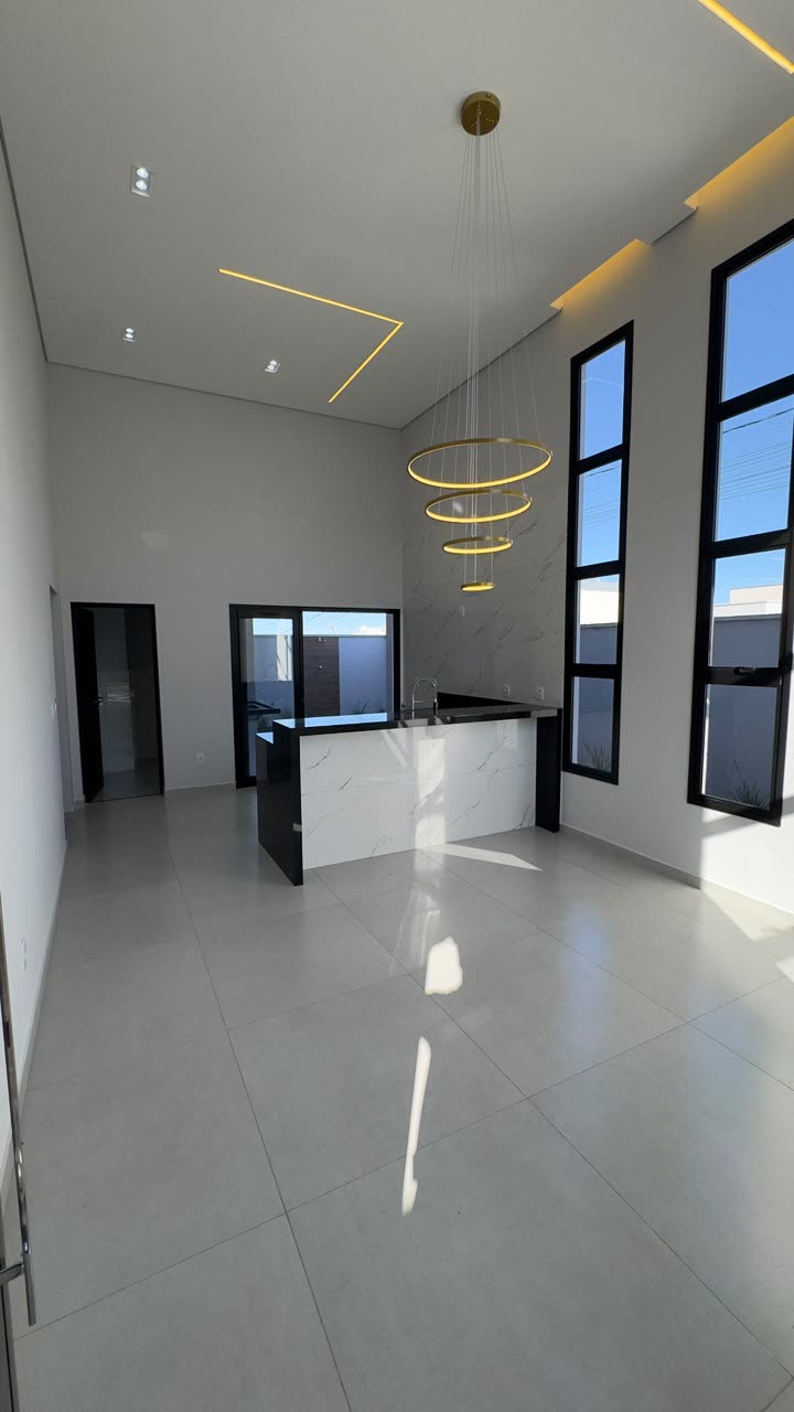 Sala ampla com pé-direito alto e lustre em anéis