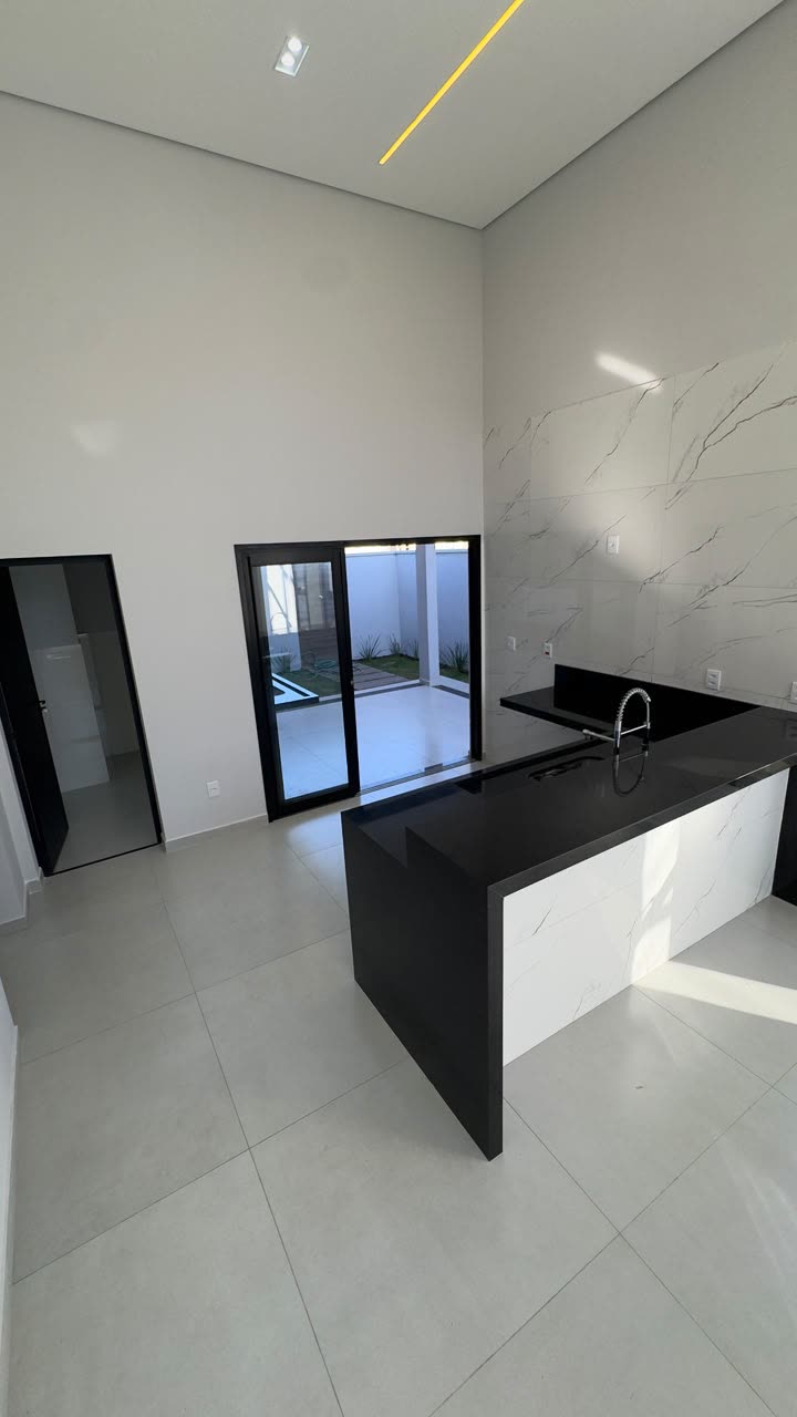 Cozinha com ilha em granito preto e revestimento marmorizado