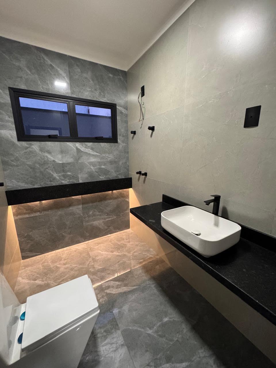 Banheiro com porcelanato e nicho iluminado