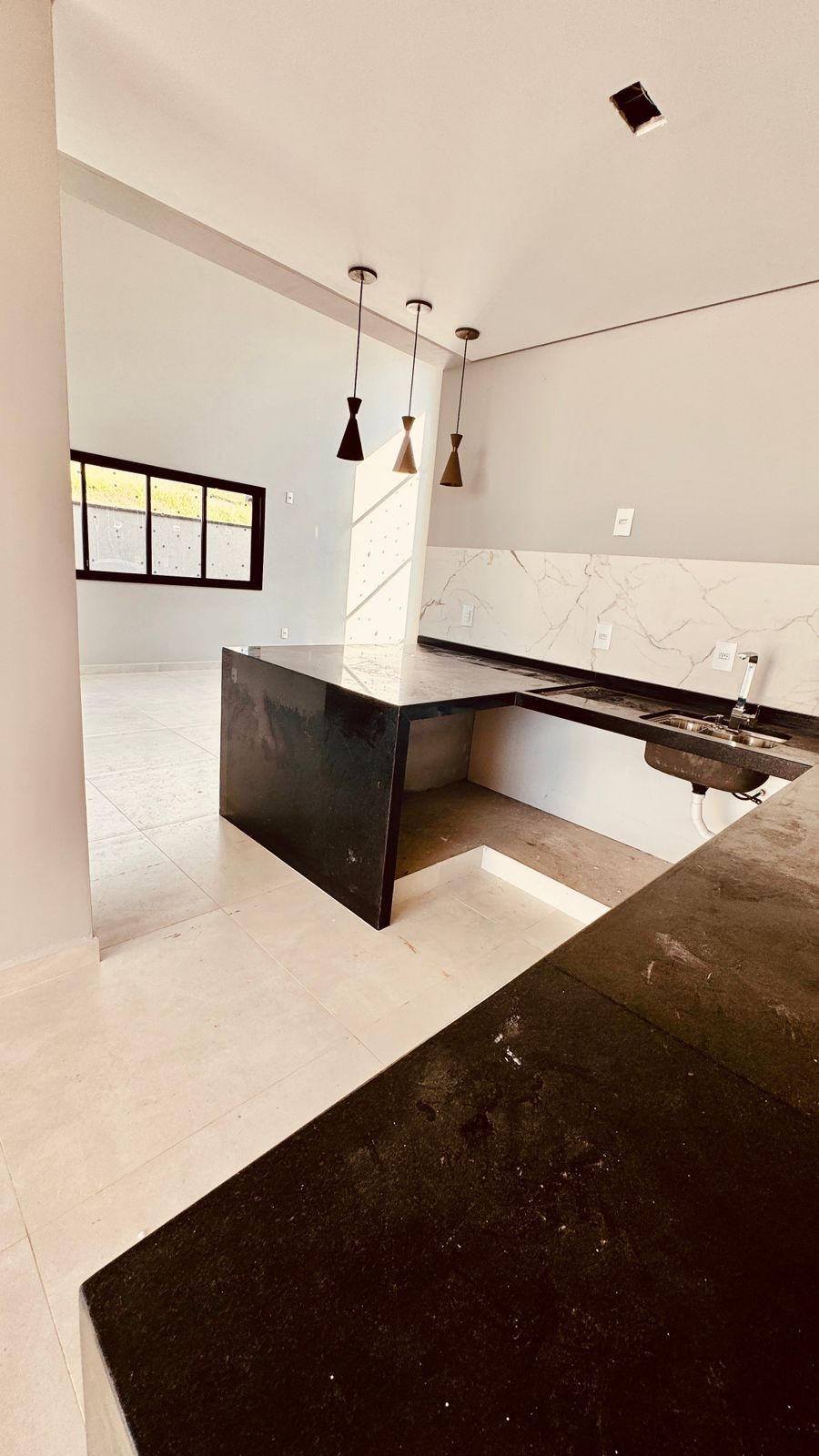 Cozinha com bancada em granito e frontão marmorizado
