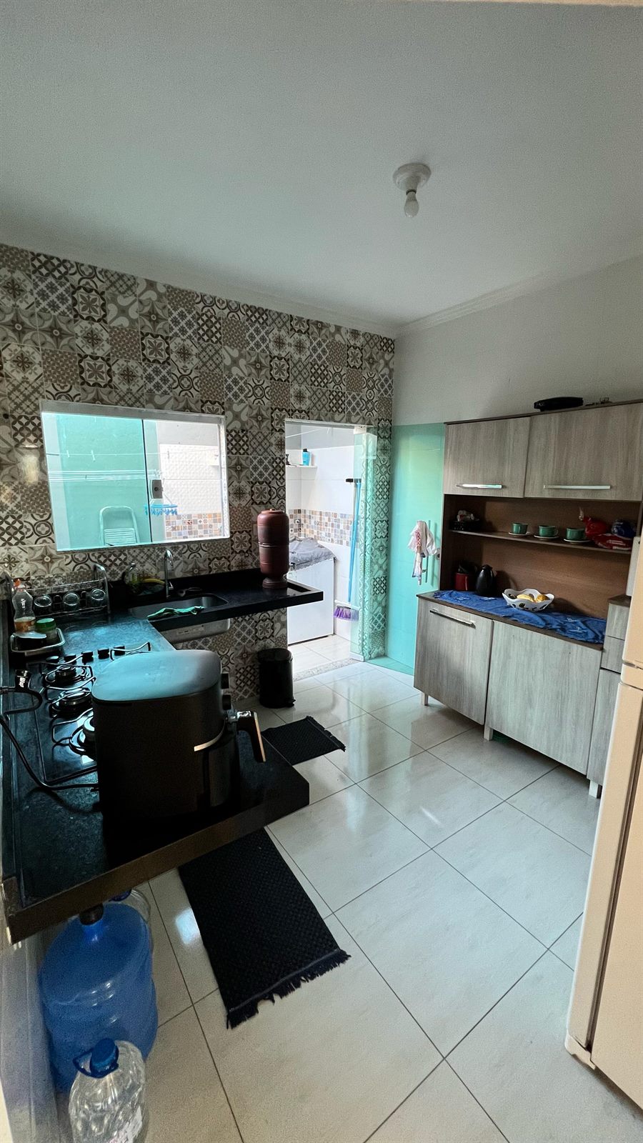 Cozinha com azulejo decorado e lavanderia