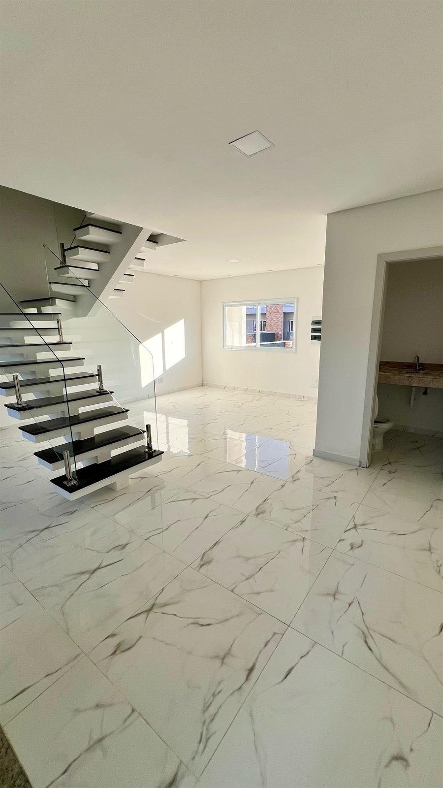 Sala com piso porcelanato marmorizado e lavabo