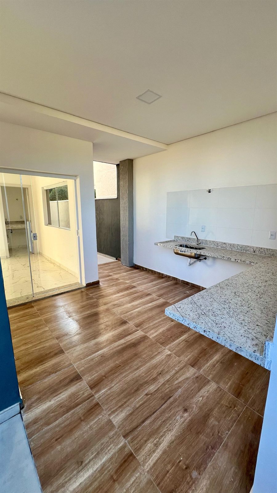 Cozinha com bancada em granito e saída para a área externa